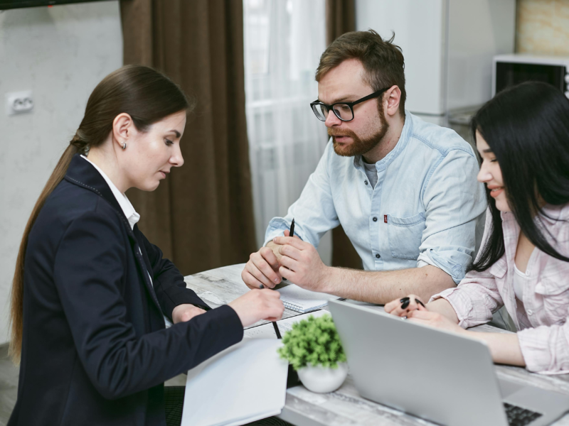 Homebuyer signing mortgage application documents with a loan office